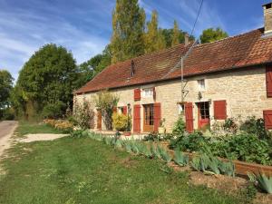 an old stone house with red doors and a garden at Fleurey la Cabotaine in Mont-Saint-Jean