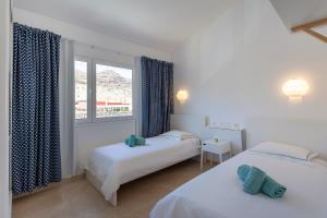 1 dormitorio con 2 camas y ventana en Zen Home Tauro, en La Playa de Tauro