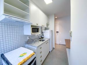 uma cozinha com armários brancos e um micro-ondas em Residencial Alto Rio Preto - São José do Rio Preto em Sao Jose do Rio Preto