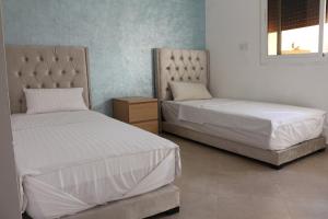 a bedroom with two beds and a night stand at Panorama Apartment Nador Jadid Klima free Parking & Wifi in Nador