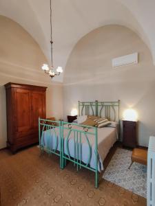 - une chambre avec un lit doté d'un cadre vert dans l'établissement CasAda, à Spongano