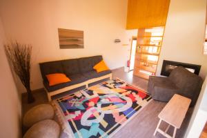 a living room with a couch and a rug at Bukubaki Eco Surf in Ferrel