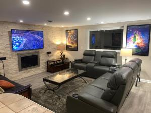 a living room with a couch and a tv at Candlewood Lake - Cozy private room by the lake in New Milford