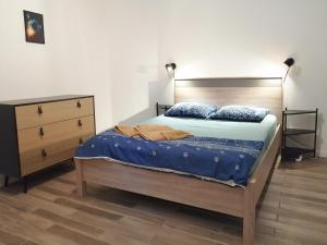 - une chambre avec un lit doté d'une tête de lit en bois et d'une commode dans l'établissement Blue Rent, à Bron