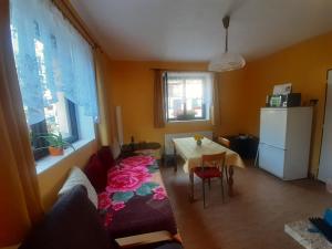 a living room with a couch and a table and window at Ralsko - Hradčany in Hradčany