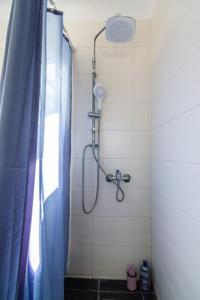 a shower in a bathroom with a blue shower curtain at Terpno Apartment in Leonidio