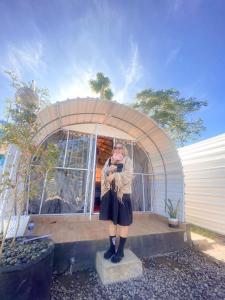 Una donna è in piedi davanti a una cupola di Glamour camping bedugul a Bedugul