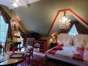 1 dormitorio con cama y lámpara de araña en Gästehaus "Villa am Eggenbach" Familie Heiss, en Eggenbach
