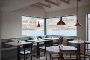 een restaurant met tafels en stoelen en een groot raam bij Kylesku Hotel in Kylestrome