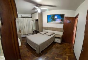a small bedroom with a bed and a ceiling fan at Marca Hotel in Nova Santa Medianeira