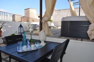 une table bleue sur un balcon avec un lit dans l'établissement La Liama di CasAda, à Spongano