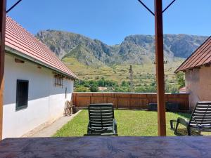2 chaises assises sur une terrasse avec des montagnes en arrière-plan dans l'établissement Félix ház, à Rimetea