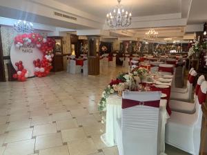 una sala da pranzo con tavoli con fiori e palloncini di Vila Royal a Bacău