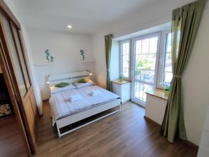 a bedroom with a bed and a large window at Bohemica Apartments in Děčín