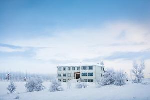 um edifício branco na neve com árvores cobertas de neve em Ljosafoss Guest House em Selfoss