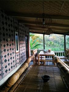 Habitación con porche con mesa y sillas. en Tetabatu Rice Terrace Homestay, en Tetebatu