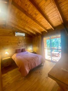 a bedroom with a bed in a wooden house at Cabaña Magnolia en Marea Delta del Tigre in Tigre