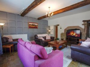 a living room with purple furniture and a fireplace at The Old Bulls Head in Chapel en le Frith