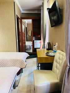 Habitación con 2 camas, mesa y TV. en Hotel Afrodita, en Truskavets