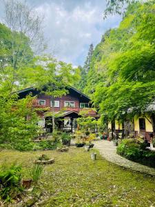 una casa en medio de un patio con árboles en Sanrinsha, en Takamori