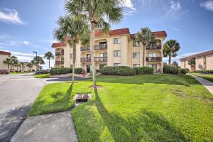 a large building with palm trees in front of it at Colorful Oceanside Condo with Beach Access! in Saint Augustine Beach