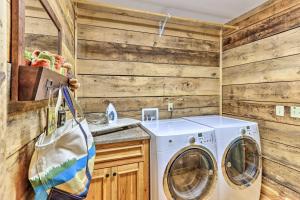 eine Waschmaschine und einen Trockner im Bad mit Holzwänden in der Unterkunft Cozy Brasstown Cabin Deck, Grill and Kayaks! in Brasstown