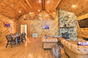 a living room with a stone fireplace and a table and chairs at Majestic Caldwell Retreat with Wraparound Deck! in Caldwell