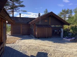 um grande celeiro de madeira com garagem em Skarehaug - koselig hytte med 3 soverom em Skadeland