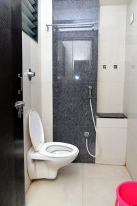 a bathroom with a toilet and a shower at Nivant Lodge in Solapur
