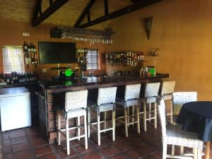 a bar in a restaurant with a bunch of chairs at Inn On Highlands in Grabouw