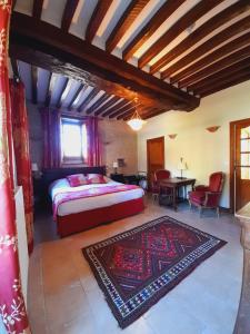 Un dormitorio con una cama y una mesa y sillas. en Chambres Résidentielles avec cuisine au Manoir de Mathan à Crépon 5 mn D'Arromanches et 10 mn de Bayeux, en Crépon