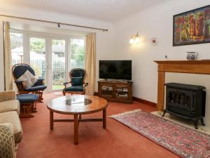 a living room with a fireplace and a tv at Hurst Green in Ewyas Harold