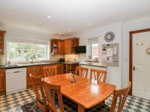 a kitchen with a wooden table and some chairs at Hurst Green in Ewyas Harold