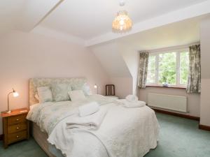 ein Schlafzimmer mit einem großen Bett und einem Kronleuchter in der Unterkunft Hurst Green in Ewyas Harold