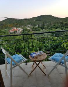 a balcony with two chairs and a table and a view at Byron House in Parga