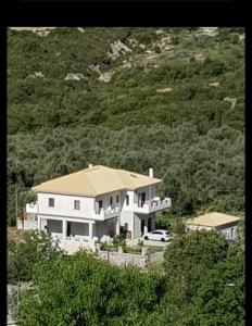a large white house sitting on top of a hill at Byron House in Parga