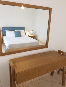 a bedroom with a mirror and a bed and a bench at Byron House in Parga