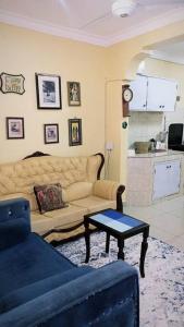 een woonkamer met een bank en een tafel bij Nimo - One Bedroom Beachroad Deluxe Apartment, Mtwapa in Mombasa