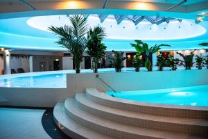 a large swimming pool with a spa with plants at Hanza Tower City View 13th floor in Szczecin