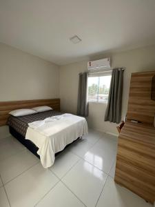 Schlafzimmer mit einem Bett und einem Fenster in der Unterkunft Pousada Praia Bela in Maragogi