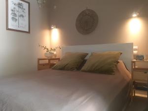 a bedroom with a white bed with two pillows at Green Rock Villa - gardens, playground and close to beach! in Agios Gordios