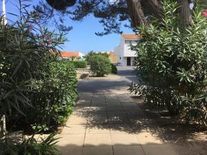 a walkway with trees and a building in the background at Marina / maison de pêcheur in Le Barcarès