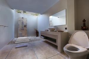 a bathroom with a toilet and a sink at Living Asia Resort and Spa in Senggigi