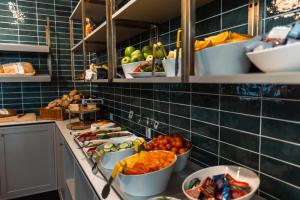 a kitchen with bowls of fruits and vegetables on a counter at Go Hotel Saga in Copenhagen