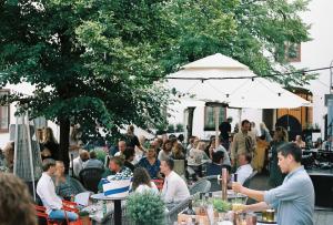una multitud de personas sentadas en mesas en un evento al aire libre en NOFO Hotel, WorldHotels Crafted en Estocolmo