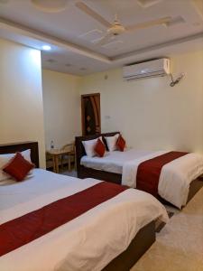 a hotel room with two beds and a table at Elite Cox's Resort in Cox's Bazar