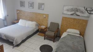 a small bedroom with a bed and a chair at Larochelle Guesthouse in Keetmanshoop