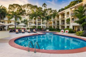 una piscina in un hotel con sedie e ombrelloni di Tamarind by Elegant Hotels - All-Inclusive a Saint James
