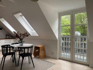 eine Küche mit einem Tisch und einigen Stühlen und Fenstern in der Unterkunft Best Stay Copenhagen Apartment 1470 in Kopenhagen