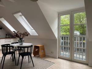 uma cozinha com uma mesa e algumas cadeiras e janelas em ApartmentInCopenhagen Apartment 1470 em Copenhague